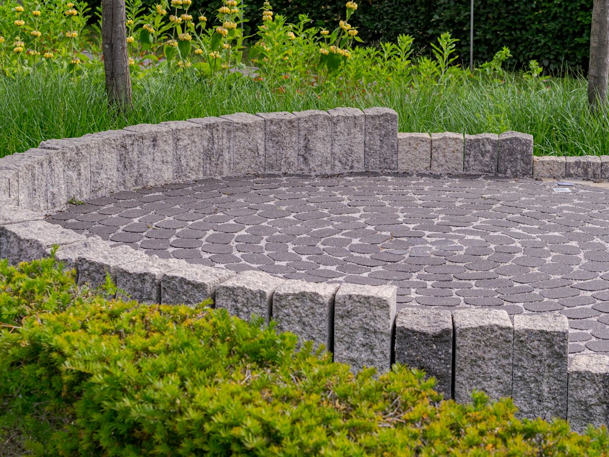 A circular granite seating area surrounded by planting